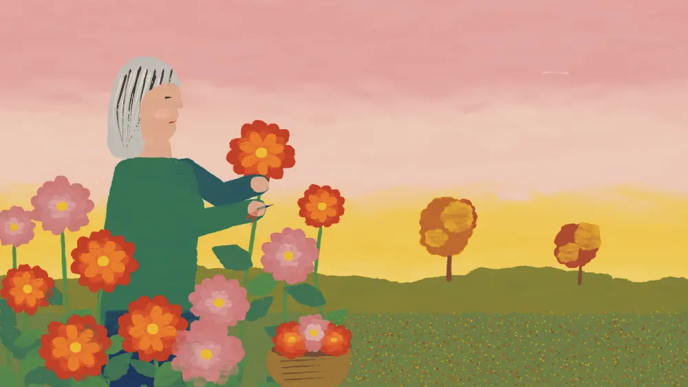 A woman with a salt-and-pepper bob cutting orange dahlias in an autumn garden.