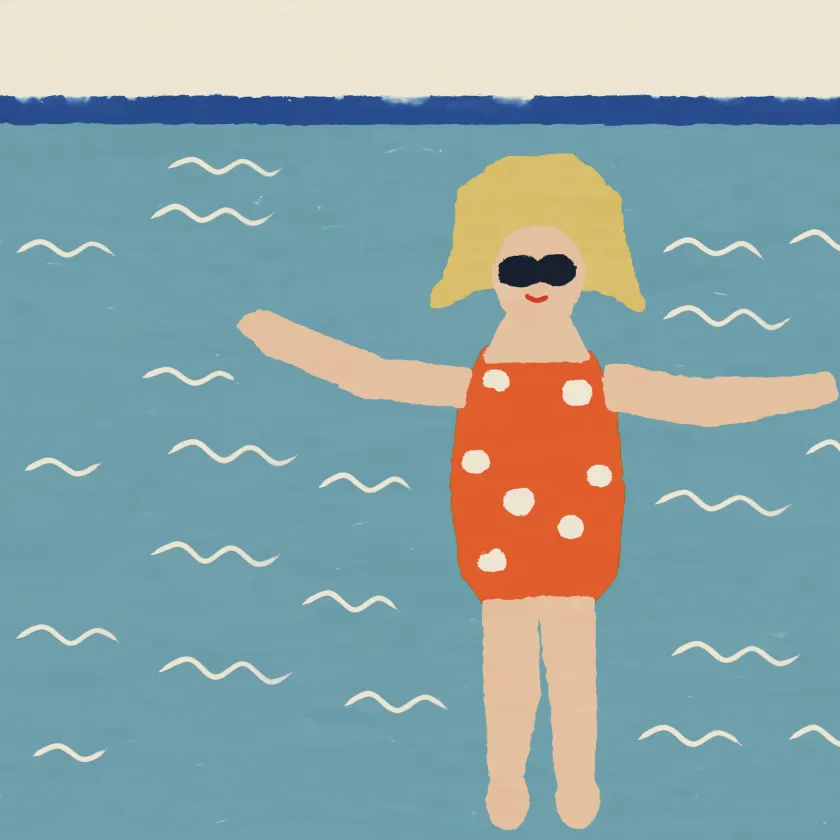 A blonde woman in sunglasses and a polka-dot swimsuit floating on turquoise water.